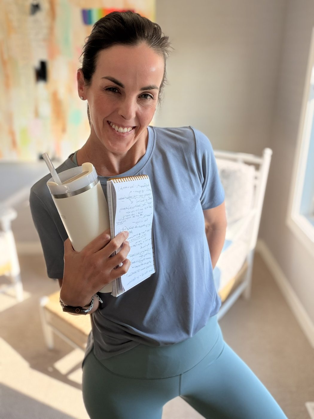 Jessica in activewear holding her handwritten notes and tumbler